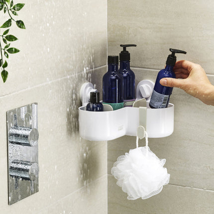 Douche rek wit in hoek-vorm met zuignappen bevestigd aan douche wand met shampoo onder stromend water