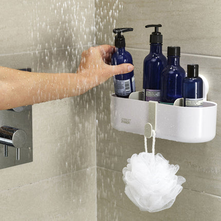 Douche rek wit met zuignappen bevestigd aan douche wand met shampoo onder stromend water