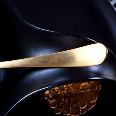 Close-up van bestek Manille goud met gouden denneappel