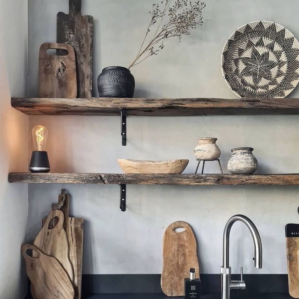 Humble One lamp dark gray in een hoek op een houten plank tussen houten kunstwerken