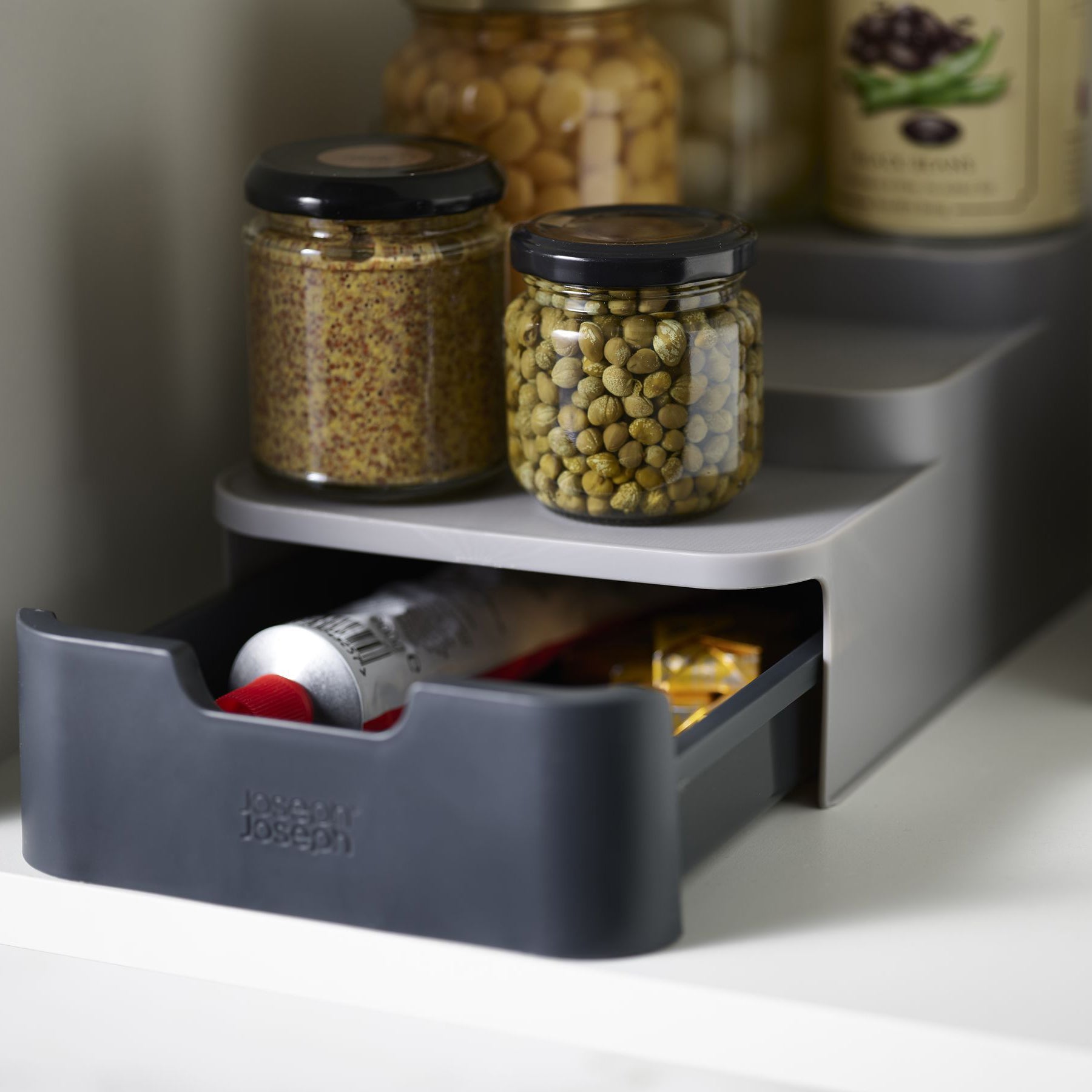 Keukenkast organizer CupboardStore compact staand van Joseph Joseph met vier glazen potten en een tube