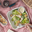 Lunchbox met salade op tafel met rood-wit geblokt tafelkleed