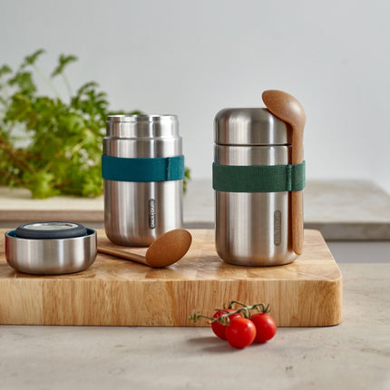 Twee Stainless Steel Food Flasks van Black & Blum op een snijplank met 3 trostomaten