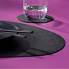 Placemat in kunstleer Stone van Kela zwart op een paarse gedekte tafel