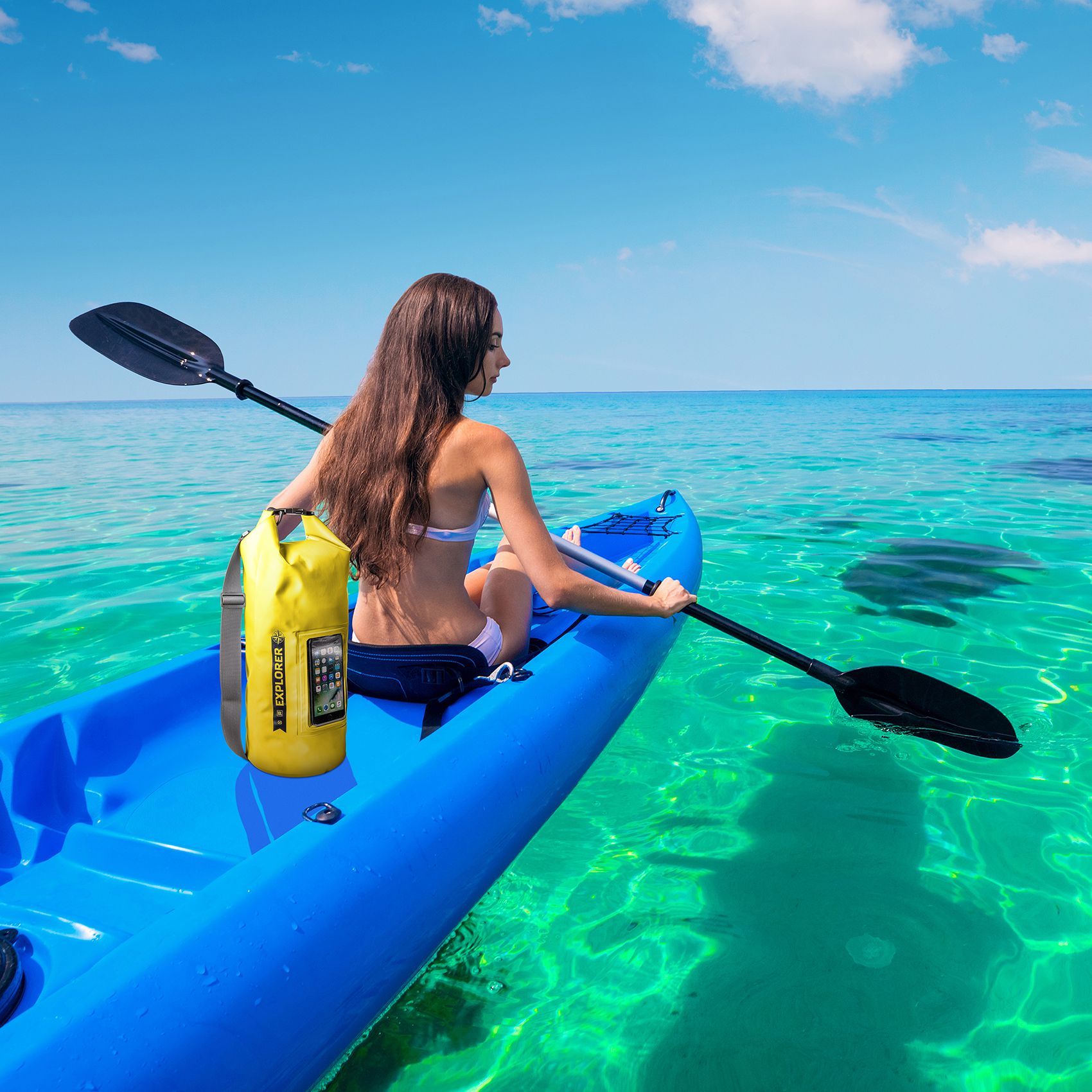 Dame in blauwe kayak met peddels in helder zee water met gele Explorer rugzak van Celly